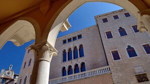 Un bâtiment doté de grandes arcades et d’une tour horloge.
