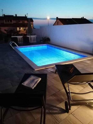 En swimmingpool med utsikt över byggnader i bakgrunden.