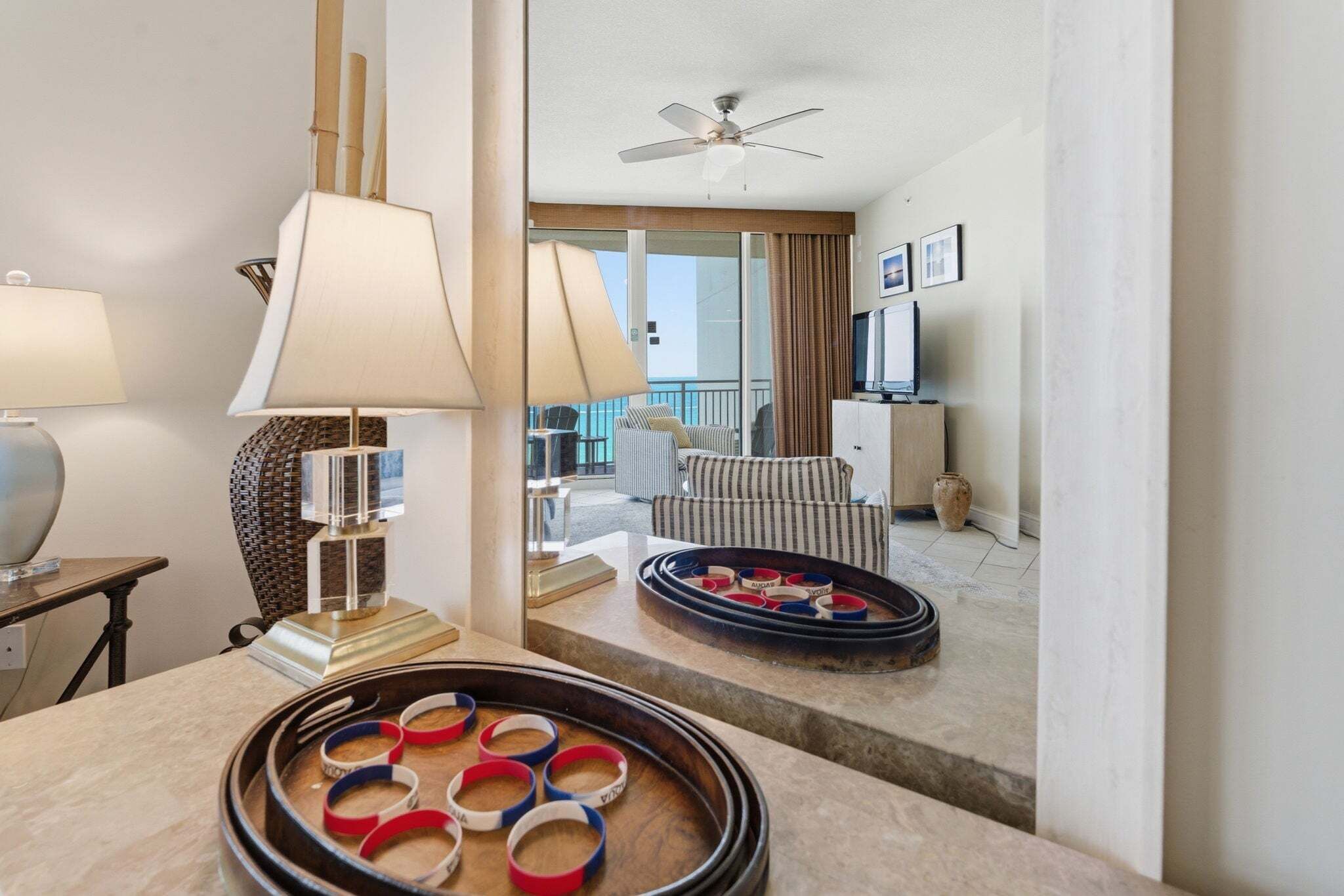 A hotel room with a dining table, a sofa, a TV, and a balcony with a view.