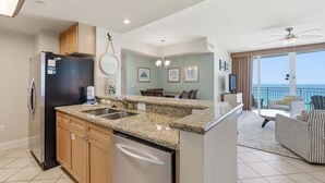 A modern kitchen with granite countertops, a built-in dishwasher, and a refrigerator. - 3 Bedroom in Aqua Resort! 811 Renovated with Gorgeous Views!  New listing (Panama City Beach)