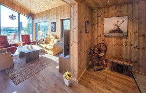 Un ampio soggiorno con pareti in legno, una grande finestra e un'accogliente area salotto.