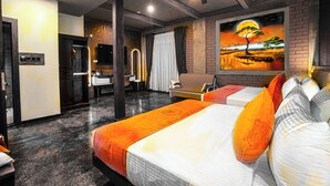 Ein Hotelzimmer mit einem Bett, einem Schreibtisch, einem Sessel, einem Fernseher und einem Bild an der Wand.