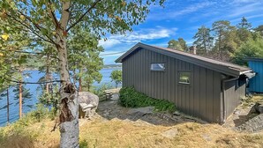A cabin with a dock, surrounded by trees and a body of water. - Nice home in Risør with house sea view (Risør)