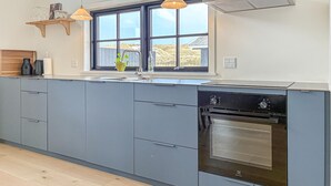 Una cucina moderna con mobili grigi, forno integrato e una finestra con vista sull'esterno.