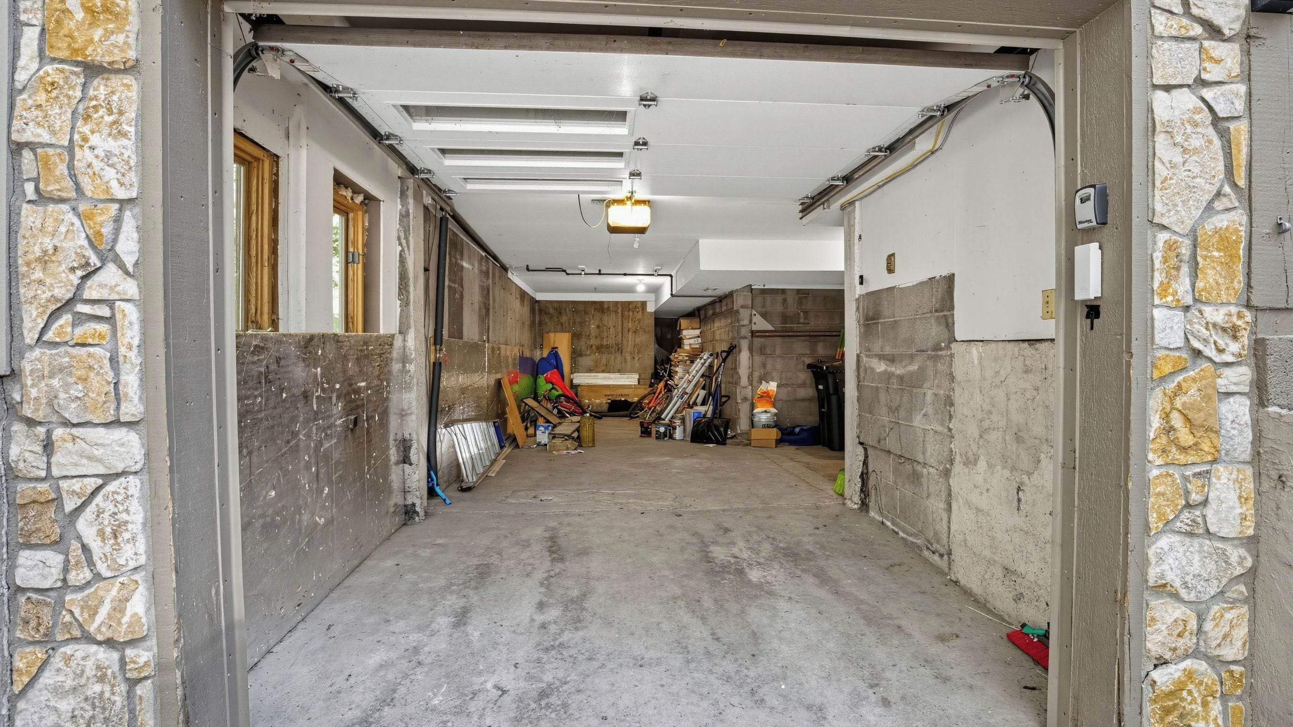 Eine Garage mit Betonboden, Steinwänden und einer Holztür.