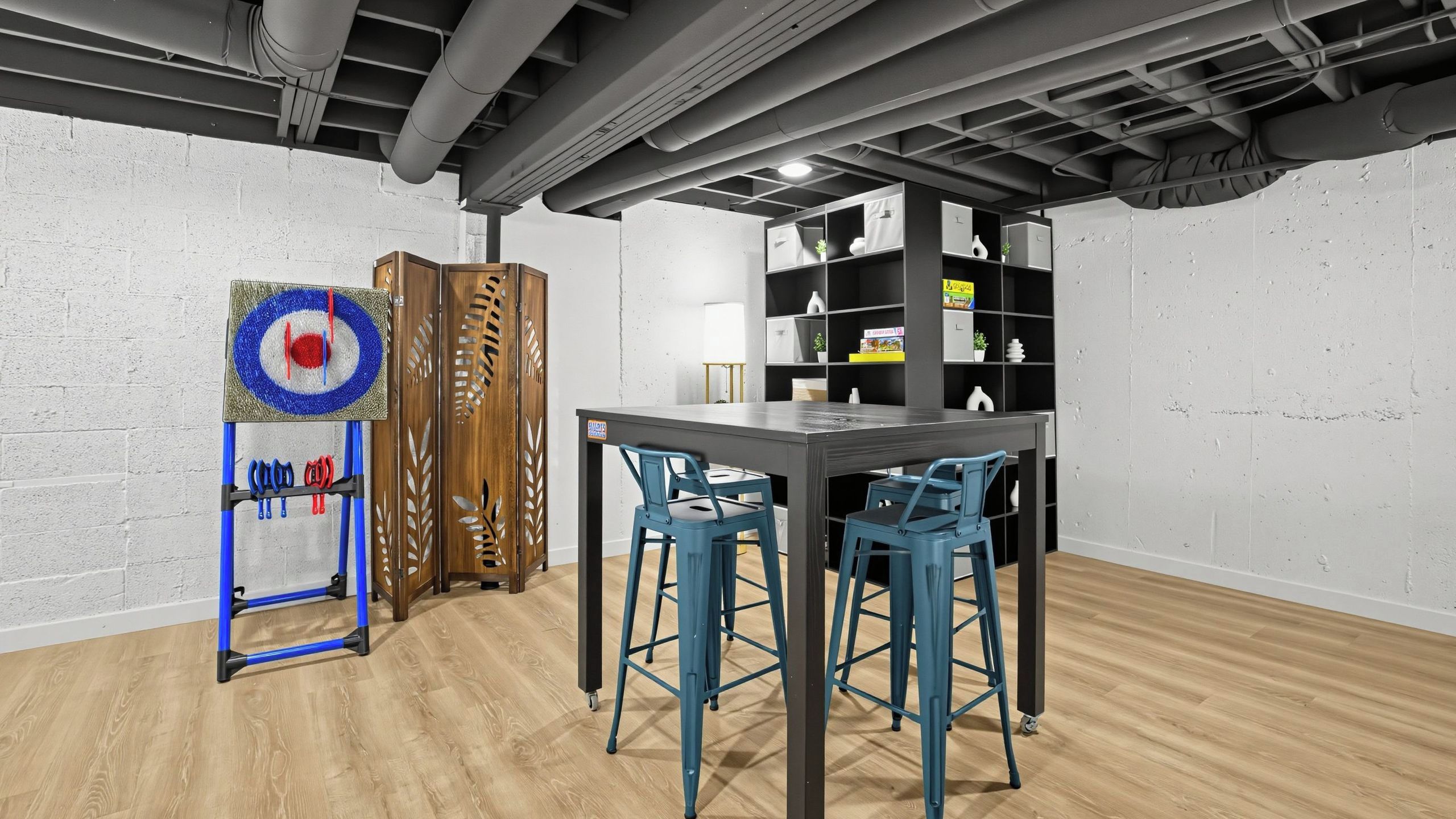 A modern office space with a wooden desk, two blue chairs, a target board, and a bookshelf.