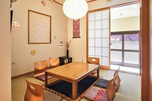 A traditional Japanese room with tatami flooring, a wooden table, and shoji screens. - Traditional House West Ikebukuro (Tokyo)
