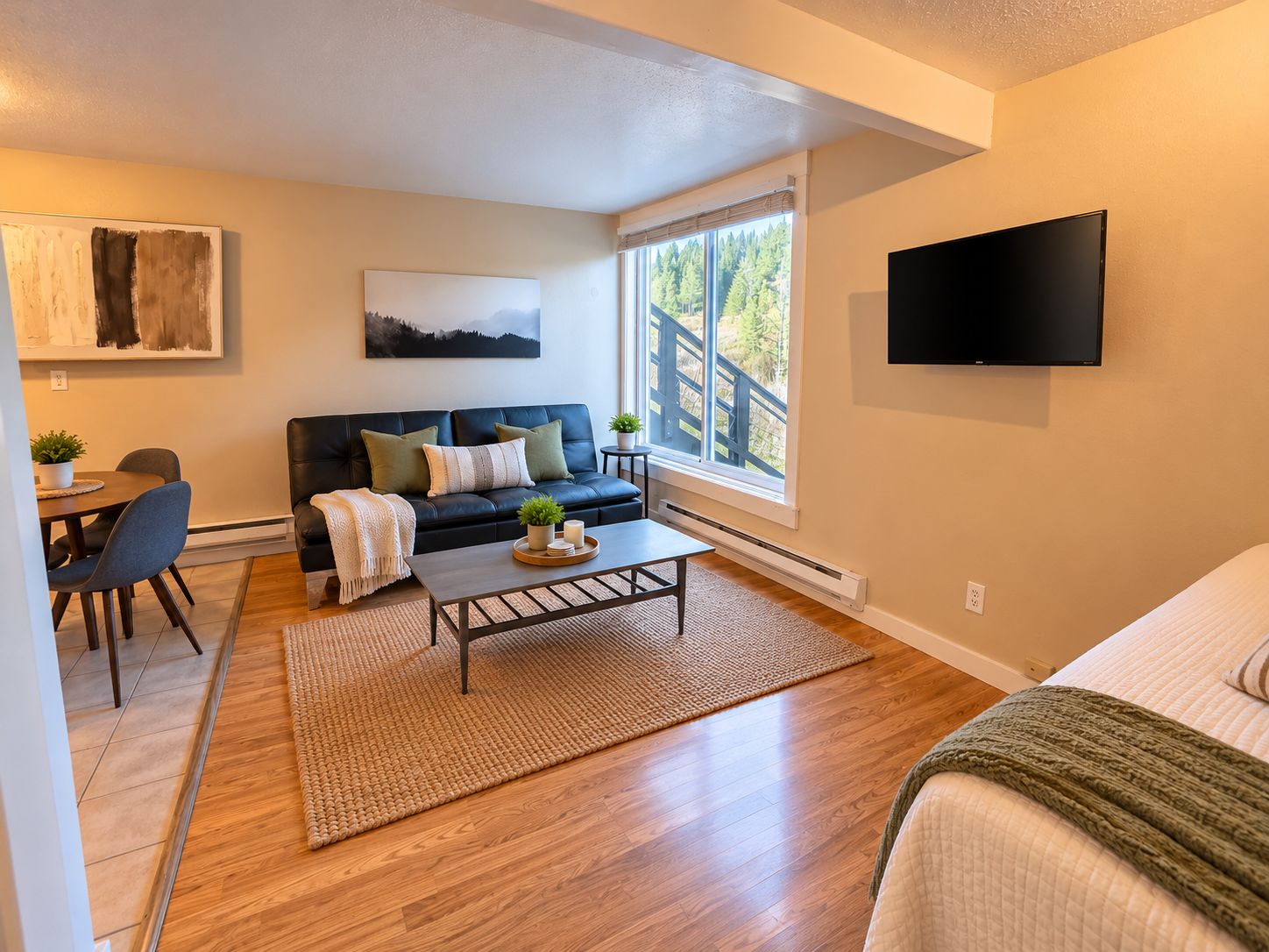 A modern living room with a sofa, coffee table, and a TV mounted on the wall.
