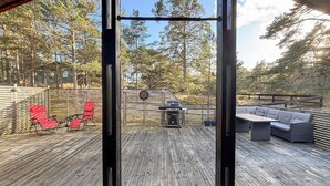Eine Terrasse mit Grill, roten Stühlen und einer Sitzecke.