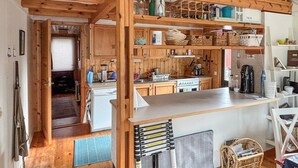 Eine kleine Küche mit Holzausbau, einer weißen Arbeitsplatte und einem eingebauten Herd.