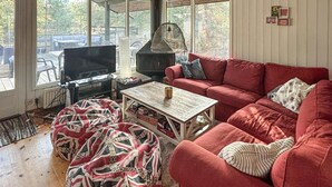 Ein gemütliches Wohnzimmer mit einem roten Sofa, einem Couchtisch und einem Kamin.