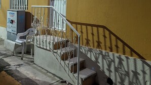A building with a yellow exterior, a metal staircase with a railing, and a door with a window. - APARTMENT IN LA SALLE 3 TUXTLA GUTIERREZ (NEAR TORRE CHIAPAS, POLIFORUM) (Tuxtla Gutiérrez)