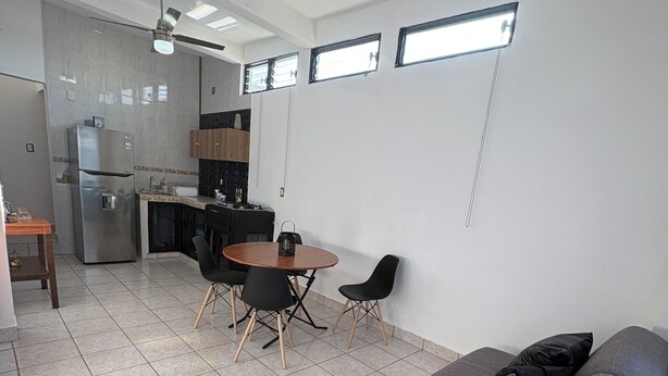 A modern living space with a sofa, dining table, chairs, a ceiling fan, and a kitchen area. - APARTMENT IN LA SALLE 3 TUXTLA GUTIERREZ (NEAR TORRE CHIAPAS, POLIFORUM) (Tuxtla Gutiérrez)