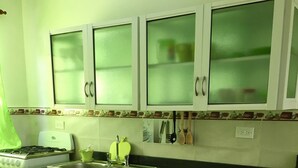 Uma cozinha com fogão, pia, armários e bancada.