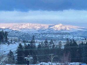Un paysage montagneux enneigé avec une ville au premier plan.