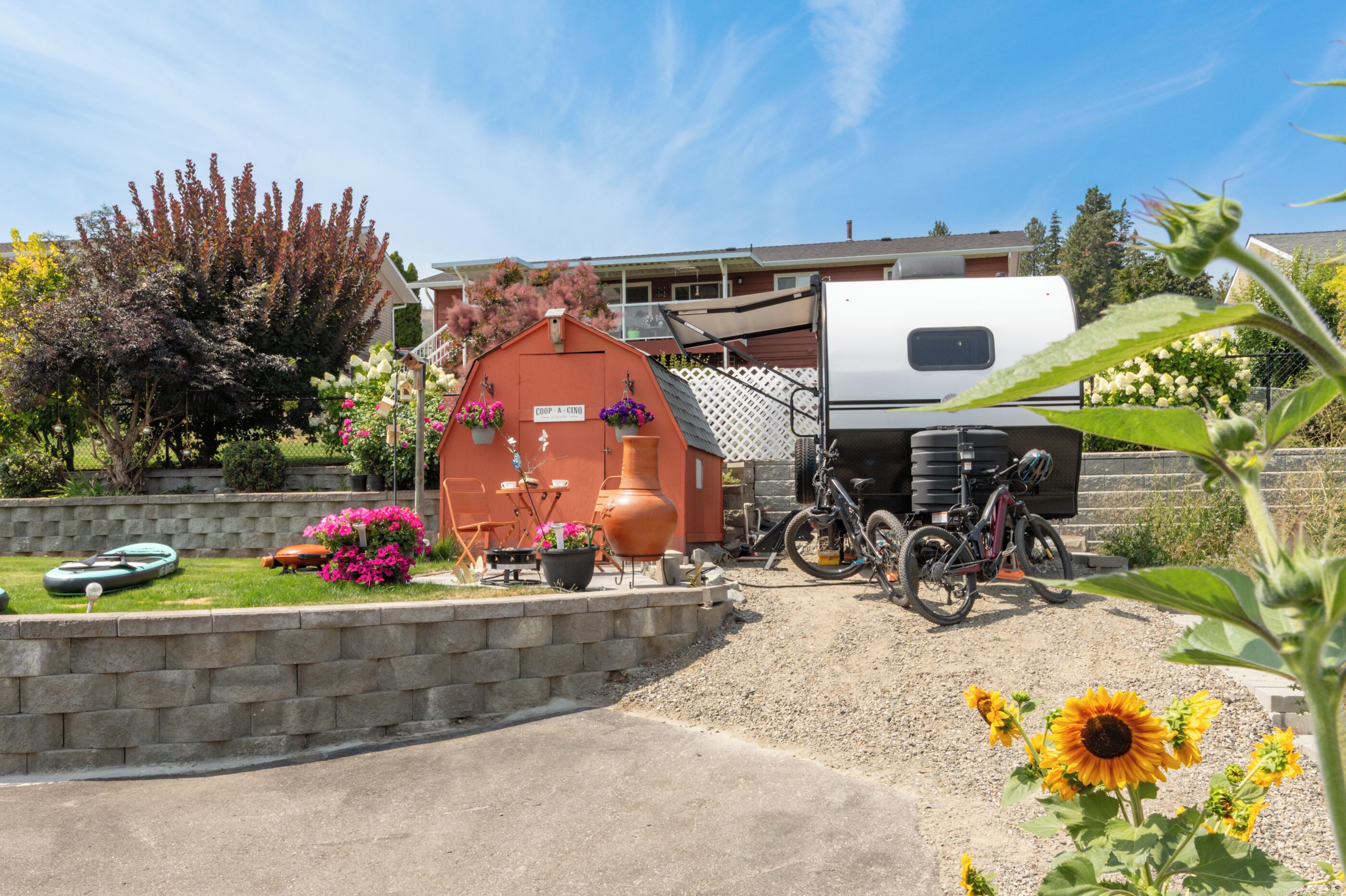 A residential area with a red building labeled 'COOP - A - CINO,' a white RV parked in front, and a bicycle.