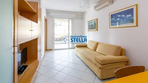 En stue med sofa, fjernsyn og spisebord.