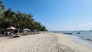 A beach with palm trees, umbrellas, and a clear sky. - Beautiful apartment in Santa Marta closer to airport with view at the sea (Santa Marta City)