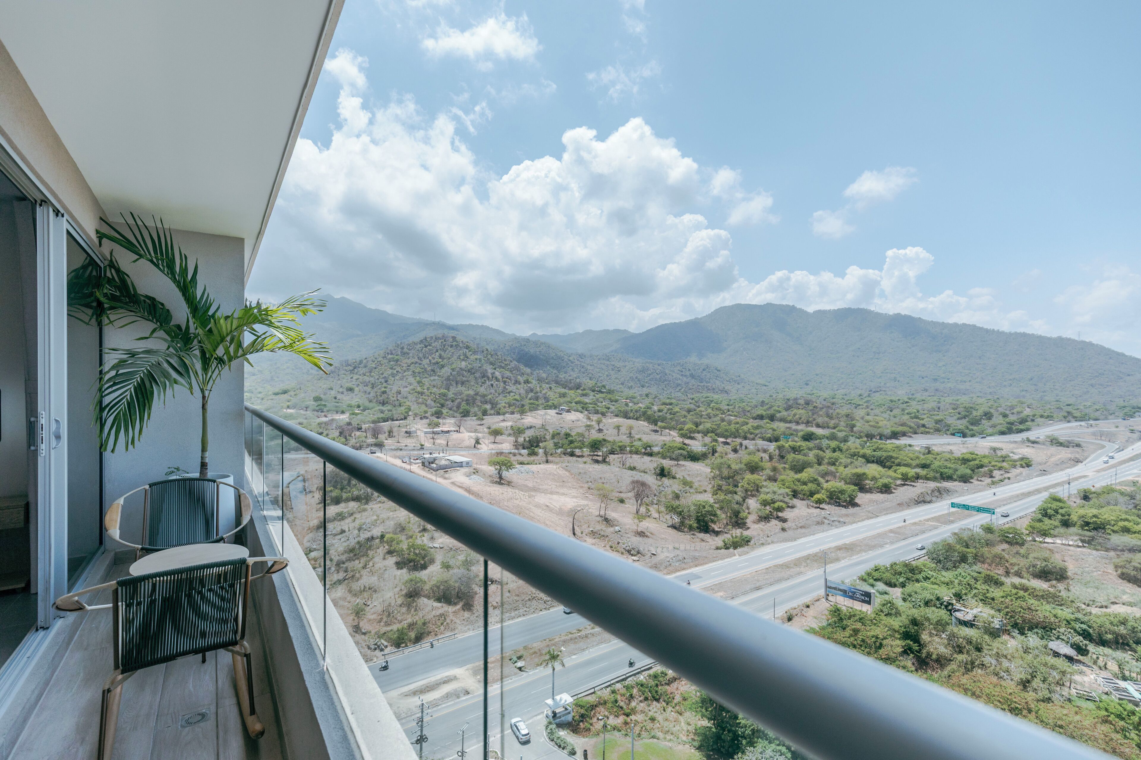 A balcony with a view of a highway and mountains.