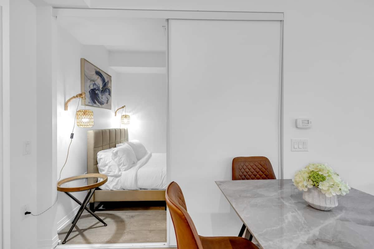 Una habitación moderna con una cama, una mesa de comedor y una silla.