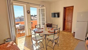 Ruokailutilassa on neljälle katettu ruokapöytä, seinälle asennettu televisio ja liukuovet, jotka johtavat ulkoilmassa olevalle parvekkeelle.