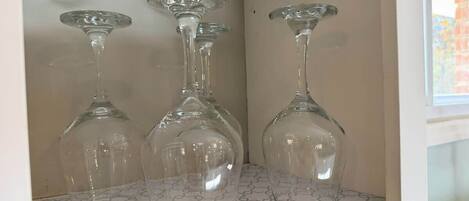 Three clear wine glasses on a shelf with a geometric patterned surface.