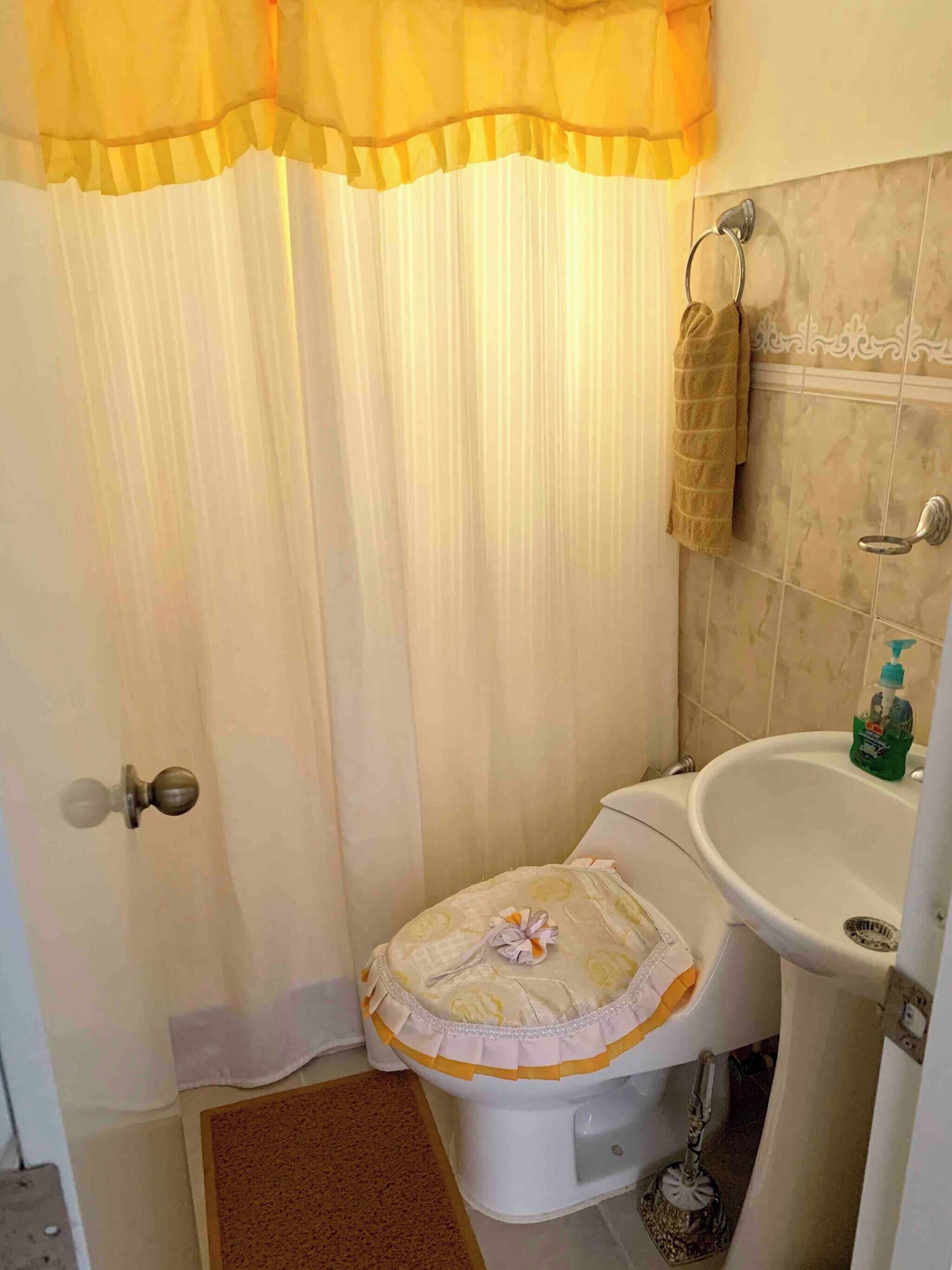 Un bagno con il water, lavandino e tenda della doccia.