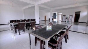 A spacious conference room with a long table and multiple chairs, a white ceiling, and a clean floor.