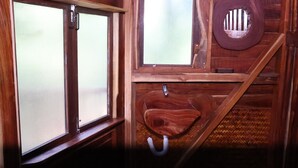 A wooden bathroom with a toilet, a window, and a sink. - Heaven In Woods (Mekkarai)