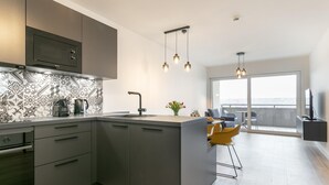 Een moderne keuken met een centraal eiland, een inbouwoven en een spatwand met patroontegels.