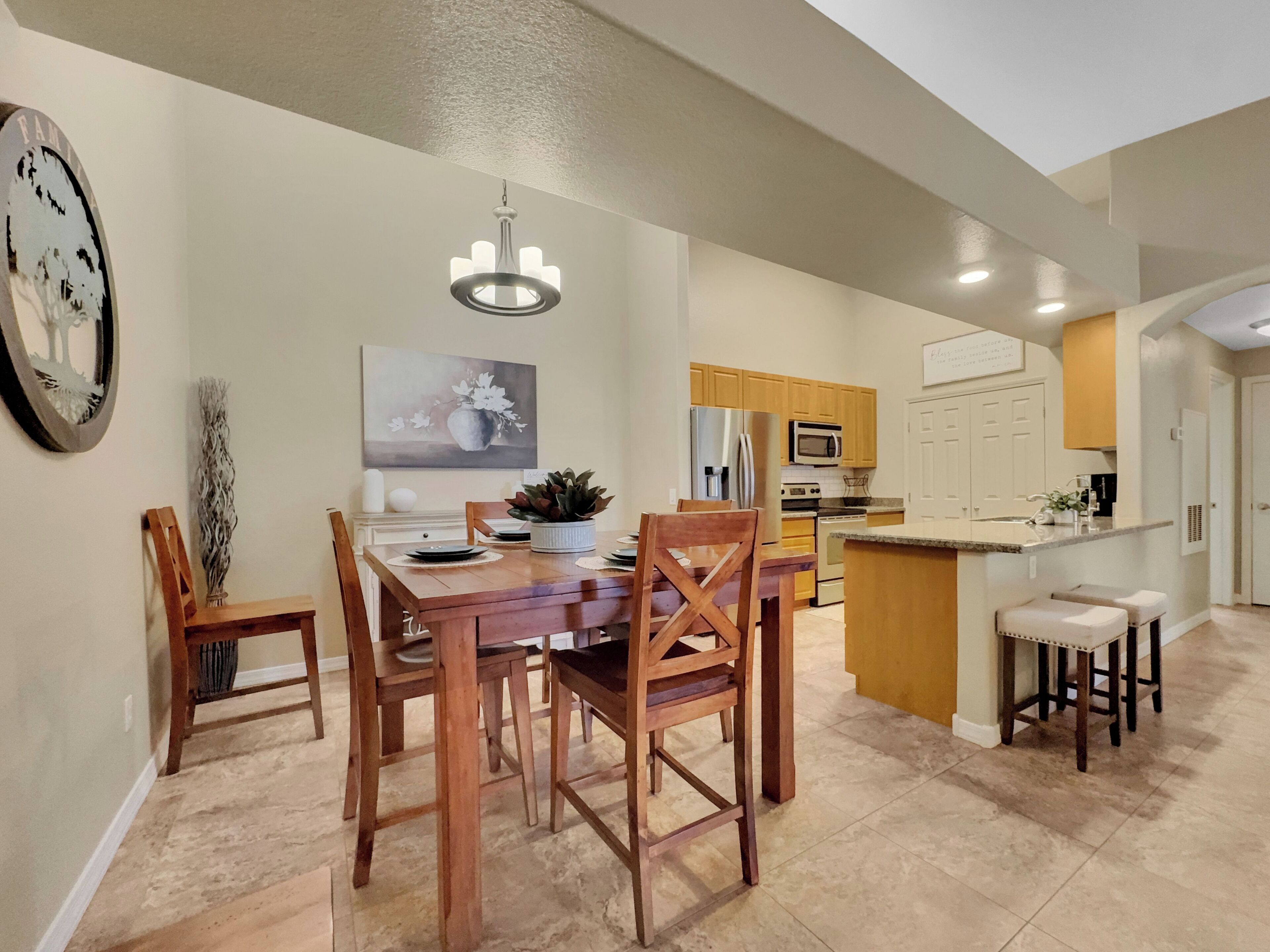 A modern kitchen with wooden cabinets, a central island, and a dining area with a wooden table and chairs.
