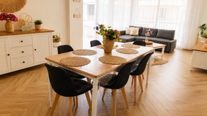 Ein Essbereich mit Holztisch, schwarzen Stühlen und gewebten Tischsets.