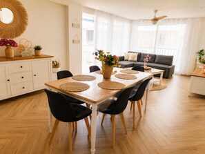 A dining area with a wooden table, black chairs, and woven placemats. - Peaceful 3-bedroom apartment in Salou near the beach (Salou)