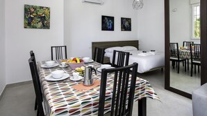 A modern hotel room with a dining area, a bed, and artwork on the walls. - Sunstay Luzon Loft III Málaga (Málaga)