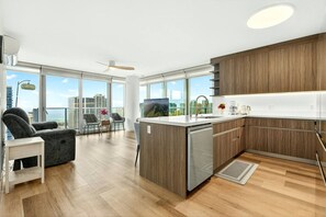 Eine moderne Küche mit Geschirrspüler, Holzschränken und Blick auf die Stadt.