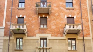 A multi-story building with balconies, windows, and a brick facade. - Crocetta Golden Soul | Design Loft near Porta Nuova (TORINO)