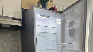 Keittiössä on jääkaappi, puukehikoiset kaapit ja laatoitettu välitila.