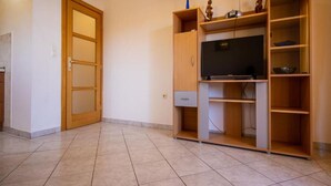 A room with a wooden cabinet, a television, and a door. - Apartment in Pasman Near Adriatic Beaches (Pasman)