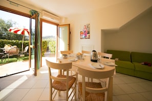A dining area with a table, chairs, and a green sofa. - Ferienwohnung fur 4 Personen in Imperia (Imperia)