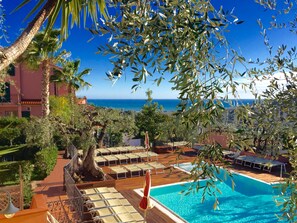 A poolside area with lounge chairs and a view of the sea. - Ferienwohnung fur 4 Personen in Imperia (Imperia)