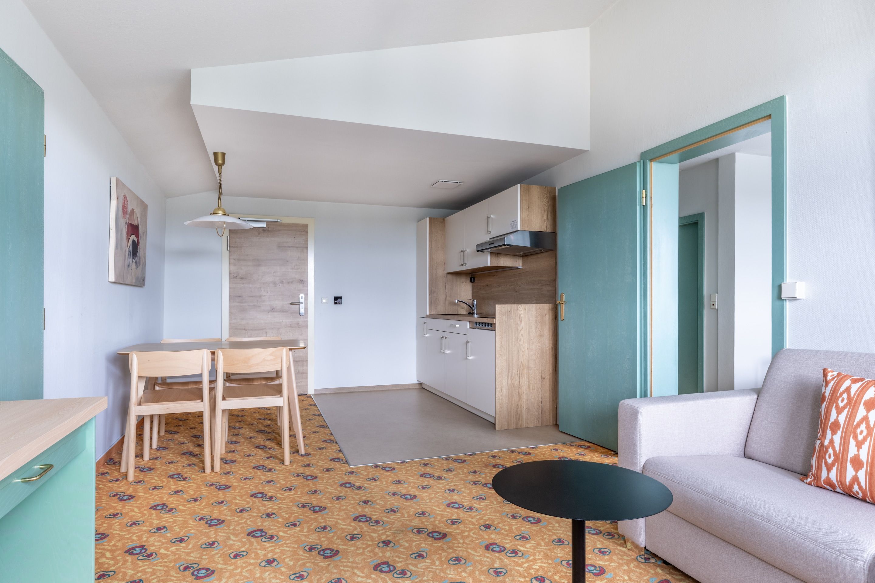 A compact living space with a kitchenette, a dining area, and a seating area.