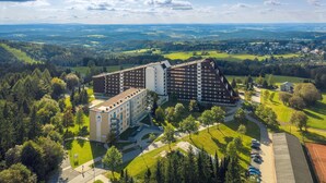 A large hotel with multiple buildings, surrounded by green fields and trees. - Studio im Ferienpark in Schoneck (Schoeneck)