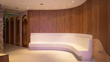 A modern lobby with a curved seating area, wooden paneling, and a sign for 'Ruhreraum.'