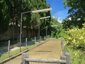 A paved path with metal fencing and street lamps, surrounded by greenery and stone walls. - Holiday Home in Citta di Castello With Pool (Città di Castello)
