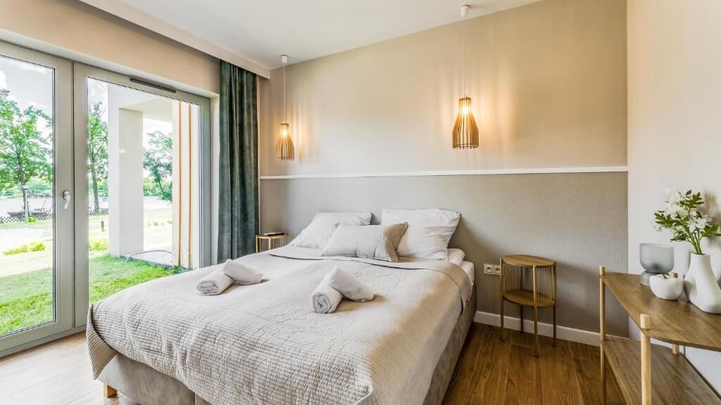 Une chambre d’hôtel avec un lit, une petite table, une chaise et une vue sur l’extérieur.