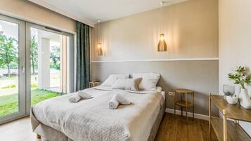 Une chambre d’hôtel avec un lit, une petite table, une chaise et une vue sur l’extérieur.
