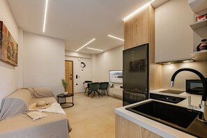 Een moderne keuken met een inbouwoven, een spoelbak en een eethoek met stoelen en een tafel.