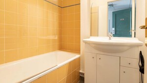 Ein Badezimmer mit Badewanne, Waschbecken und Spiegel.