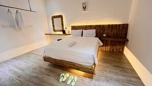 Une chambre à coucher avec un lit, une tête de lit en bois, une table de chevet et un miroir fixé au mur.