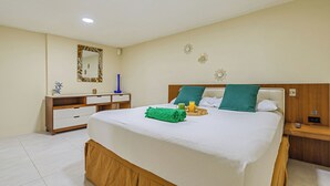 A neatly arranged bedroom with a bed, bedside table, nightstand, dresser, and a mirror on the wall. - IslaRita Stays - spacious studio near Eagle Beach (Oranjestad)